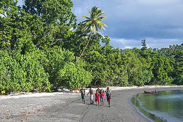 Local boys walking on a pretty black sand volcanic beach, Epi Island, Shepherd Islands, Vanuatu, Pacific