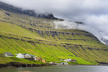 Little village below the cliffs of Kunoy, Faroe Islands, Denmark, Europe