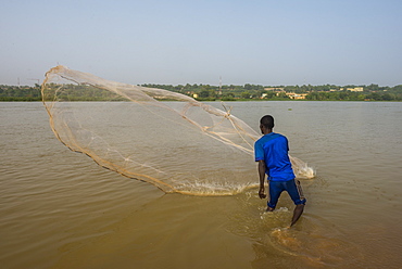 Fisherman throwing his fishing net into the River Niger, Niamey, Niger, Africa