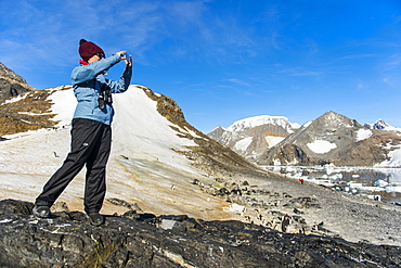 Tourist photographing the beautiful bay filled with icebergs in Hope Bay, Antarctica, Polar Regions