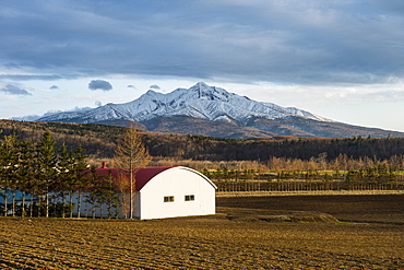 Little farm before a snow capped mountain near the Shiretoko National Park, Hokkaido, Japan, Asia