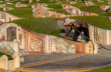 Worker looking after tombstones at Chinese cemetery, Chiang Mai ,Thailand, Southeast Asia, Asia