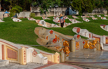 Worker looking after tombstones at Chinese cemetery, Chiang Mai, Thailand, Southeast Asia, Asia