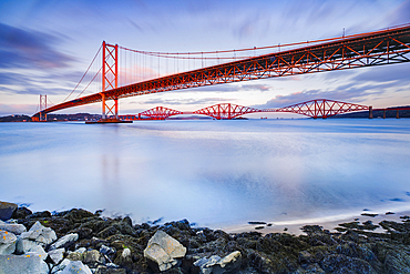 Forth Road Bridge and the red Forth Bridge railway crossing, UNESCO World Heritage Site, beyond, lit by evening light, view from the Fírth of Forth in South Queensferry, near Edinburgh, Scotland, United Kingdom, Europe