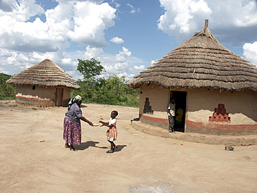 Zambia 7-year-old constance mabo of chikwela village, chongwe, with her grandmother rita, in front of her house