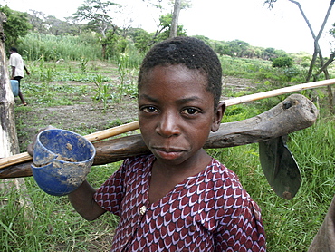 Zambia boy of kasisi carrying a hoe