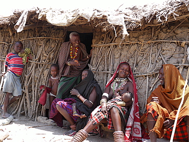 TANZANIA Watatulu tribesmen of Miyuguyu, Shinyanga district. Family group by the doorway of their mud and stick house. photograph by Sean Sprague