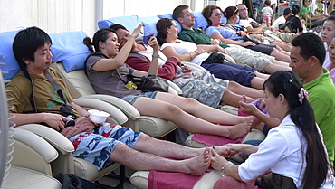 THAILAND Chiang Mai.Tourists getting foot and leg massage in the street. Photo by Sean Sprague