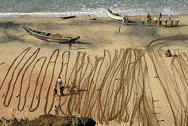 India fishermen arranging their nets on the beach. Varkala beach resort, kerala.