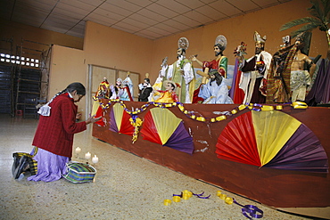 Guatemalawoman praying in front of religious statues, marcos saquateprquez.