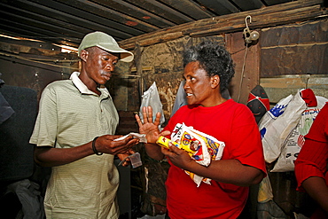 Namibia a voluntary home visitor (right) of catholic aids action visiting a suffering from. is giving a nutrition supplement (anti retro viral) tablets. Rehobeth