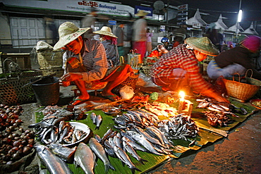 Myanmar traders selling fish with candle stalls at night market at myitkyina, a largely kachin community in north burma near chinese border 