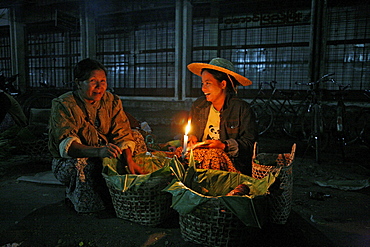 Myanmar traders selling food from candle stalls at night market at myitkyina, a largely kachin community in north burma near chinese border 