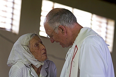 Jamaica. Old woman of german origin talking to american priest during sunday mass in the catholic church at seaford town