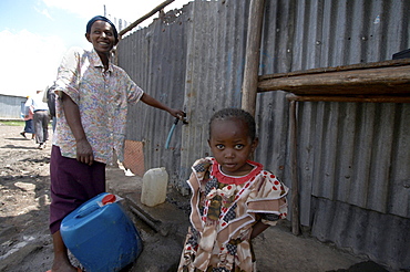 Kenya. Woman collecting water from public tap in mukuru ruben, a slum of nairobi