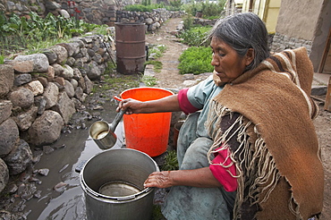 Peru. Woman washing pots, yanque, colca canyon