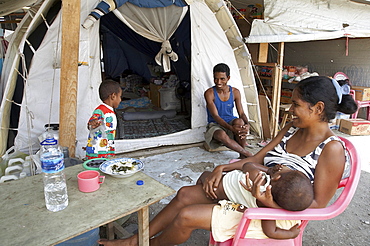 East timor. Family in front of their tent at the camp for internally displaced people (idps) located at the police academy in dili