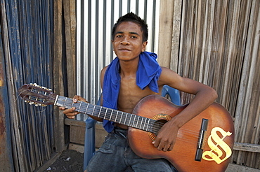 East timor. Boy playing guitar, topu honis orphanage and childrens home, oecussi-ambeno