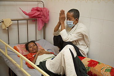 Cambodia seedlings of hope hospice for aids patients, phnom penh. woman saying buddhist chants to another who is dying of aids