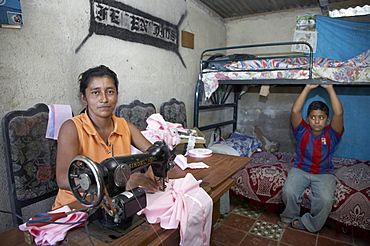 El salvador family of teresa de jesus perez, 36, hiv+, left with three sons, one of whom, 8-year-old raphael, is also hiv+. they are supported by contra sida, san salvador. teresa supports herself and family by sewing blouses and dresses at home, shown here with sons raphael, who is hiv+ (on left) and jose, who is not infected