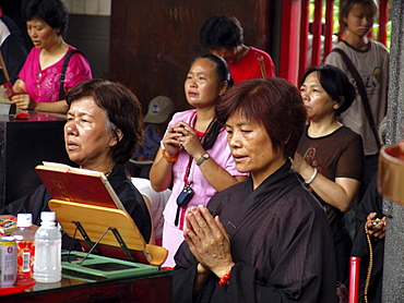 Religion, taiwan. The lungshan temple, dedicated to kuanyin, the goddess of mercy. Taipei. Worshippers at the temple