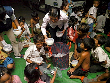 CAMBODIA Children receiving food during and informal lesson run by the CSARO outreach team, Phnom Penh