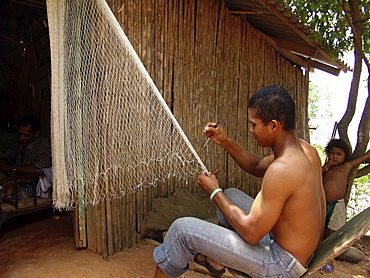 Colombia fisherman repairing his nets at a small village near barrancabermeja on the rio magdalena