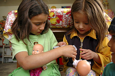 Colombia sisters playing with their dolls, the slum of altos de cazuca, bogota,