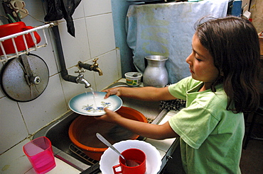 Colombia marly juliet, 7, of the slum of altos de cazuca, bogota, washing dishes