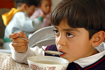 Colombia boy eating soup, ciudad bolivar, bogota