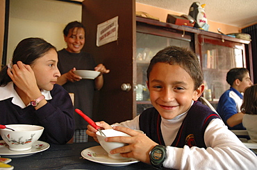 Colombia day in the life series: hugo andres, 7, of ciudad bolivar, bogota, with his sister a lineth, eating lunch at a soup kitchen for the poor