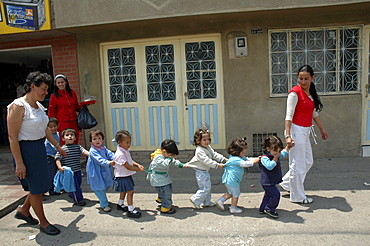 Colombia children in crocodile formation walking to their day care center, ciudad bolivar, bogota,