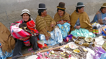 BOLIVIA Street scenes in Achacachi. Aymara women gathered to eat meal on street during festival