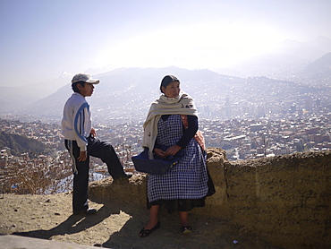 BOLIVIA Street scenes in La Paz. Man and woman standing on edge of El Alto