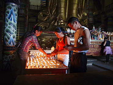 Mongolia ligthing candles inside migjid janraisig sum temple at gandan monastery, ulaan baatur