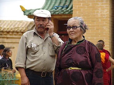 Mongolia old couple, man on cell phone, gandan buddhist monastery and temple, ulaan baatar