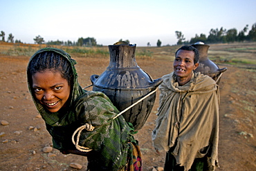 Women fetching water early in the morning. The wells in this area are empty during the dry season,forcing women to walk very long distance to fetch water in the nearest river bed. Ethiopia