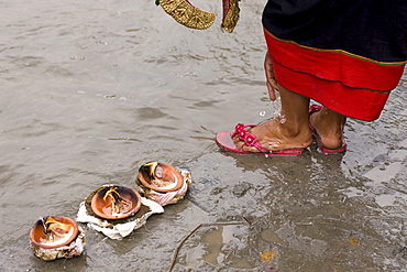 Butter lamp offerings to the Bagmati River flowing next to Brahmayani Temple. Newar Village Women wears "Haku Patasi" to the Temple. (Haku Patasi is garb worn by Newari woman). Bhaktapur, Nepal