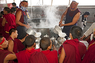 Volunteer monks make tibetan butter salt milk tea in gigantic vessel for the kalachakra initiation attendants. Kalachakra initiation in bodhgaya, india  