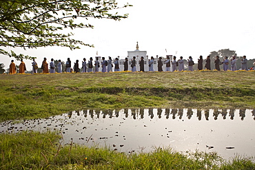 Buddhist pilgrims circumambulate the mayadevi temple and the pond in front of it. Lumbini, nepal