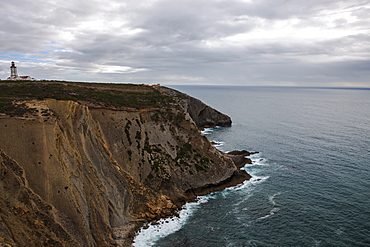 The Cabo Espichel coast on the Atlantic Ocean with lighthouse in the distance, Lisbon, Portugal, Europe