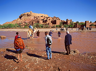 Tourists cross river Asif Mellah to visit Kasbah Ait Ben Haddou, UNESCO World Heritage Site, near Ouarzazate, Morocco, North Africa, Africa