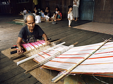 Iban woman weaving pua kumbu, in complex traditional patterns and reated to old head-hunting rituals, Katibas River, Sarawak, Malaysia, island of Borneo, Southeast Asia, Asia