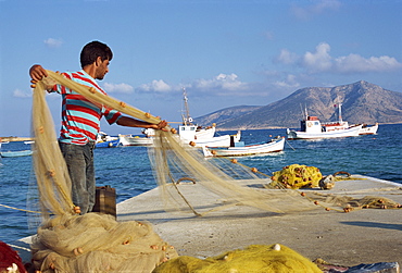 Fisherman sorting his nets, harbour of island of Koufounissia, Lesser Cyclades, Greek Islands, Greece, Europe