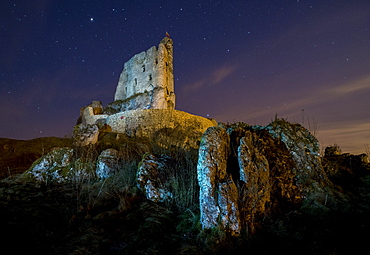 View of rocks and Mirow Castle ruins illuminated at night, Polish Jura, Poland, Europe