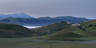 Fields of Piano Perduto, Monti Sibillini Mountains and the village of Castelluccio di Norcia at dawn, Umbria, Italy