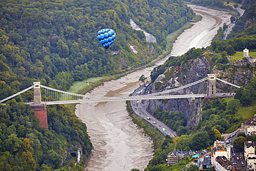 A hot-air balloon flying over Clifton Suspension Bridge, an icon of Bristol, during the Bristol International Balloon Fiesta, Bristol, England, United Kingdom, Europe