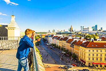 Couple looking at Palace of Culture and Science and skyscrapers, City Centre, Warsaw, Poland, Europe