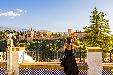 Woman taking a photo of Alhambra and Sierra Nevada mountains, Granada, Andalucia, Spain, Europe