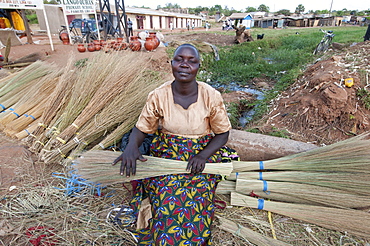 Woman selling home-made brushes by the side of the road, Lira, Uganda, Africa